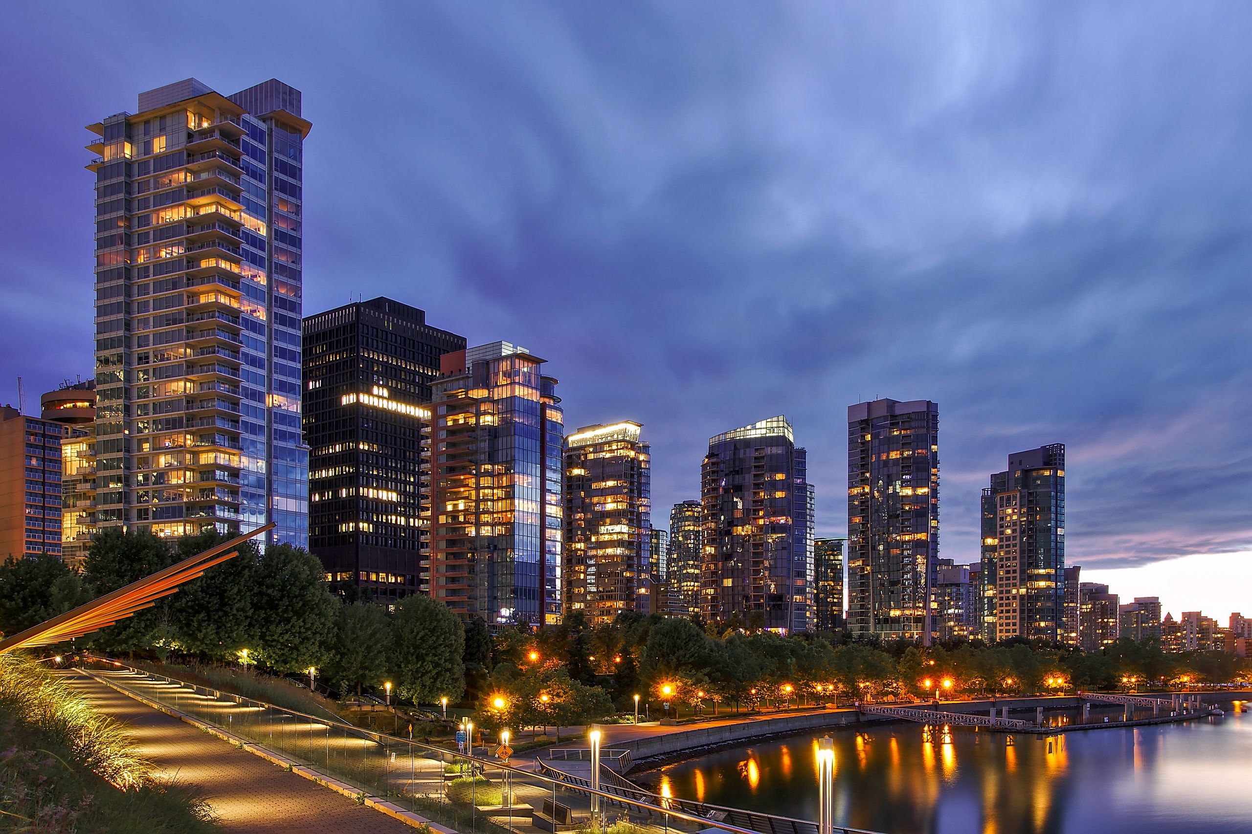 Coal Harbour waterfront in Vancouver at blue hour with city lights and marina views.